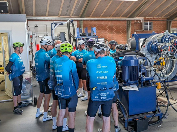Cyclists from Lemvig Cycling Club on a tour of AS SCAN’s production facilities, looking at large technical machinery.